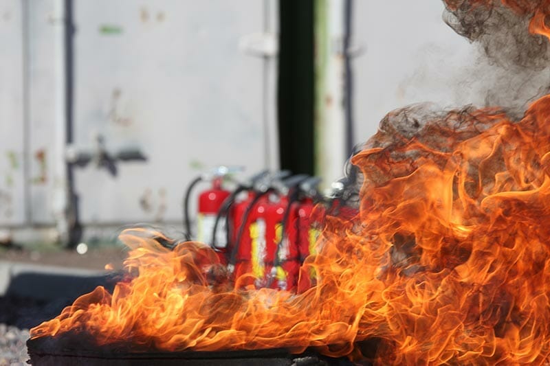 Fire extinguishers behind flame